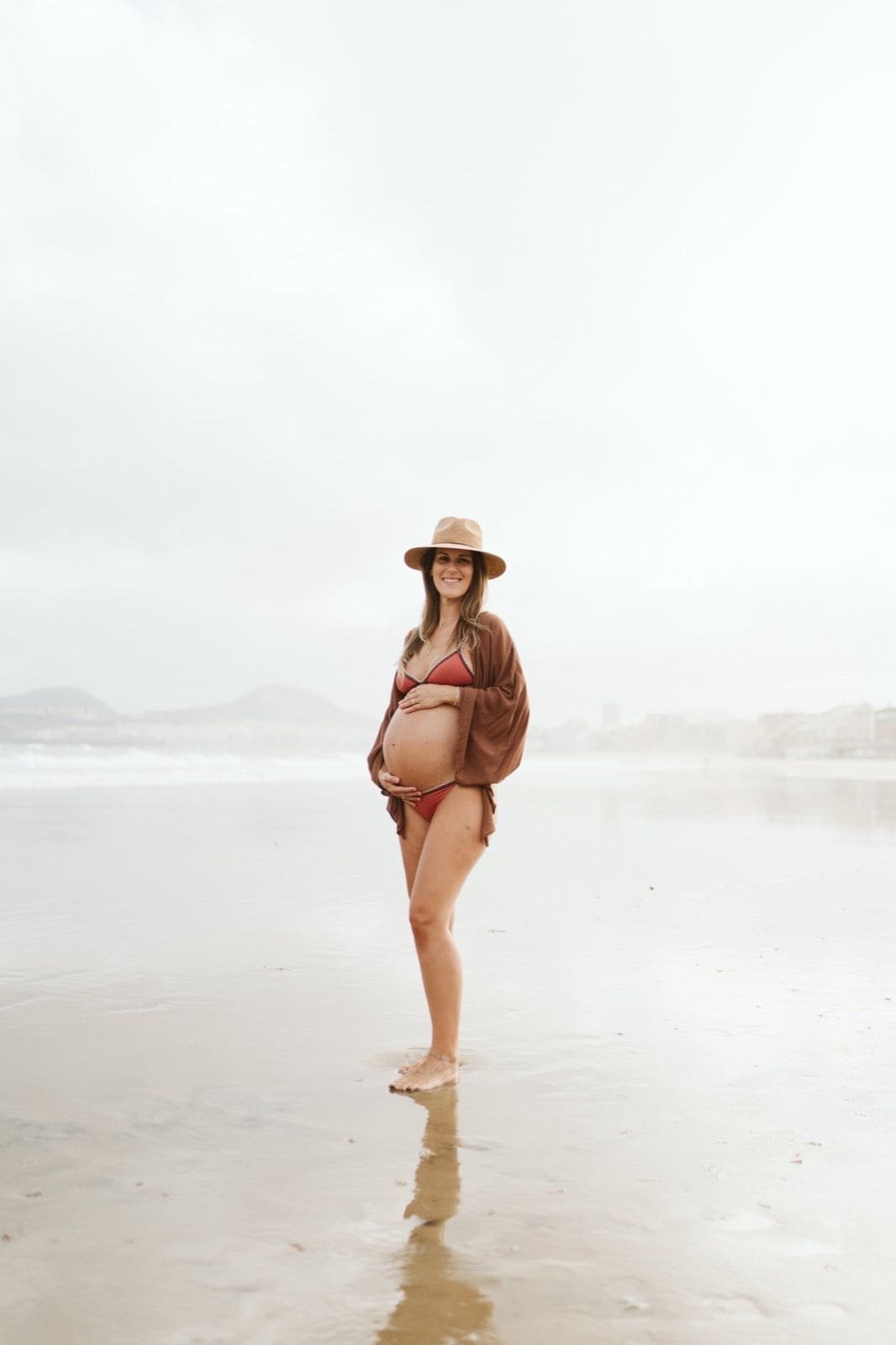 Mujer embarazada posando con serenidad en la arena de la playa de Las Canteras, Gran Canaria