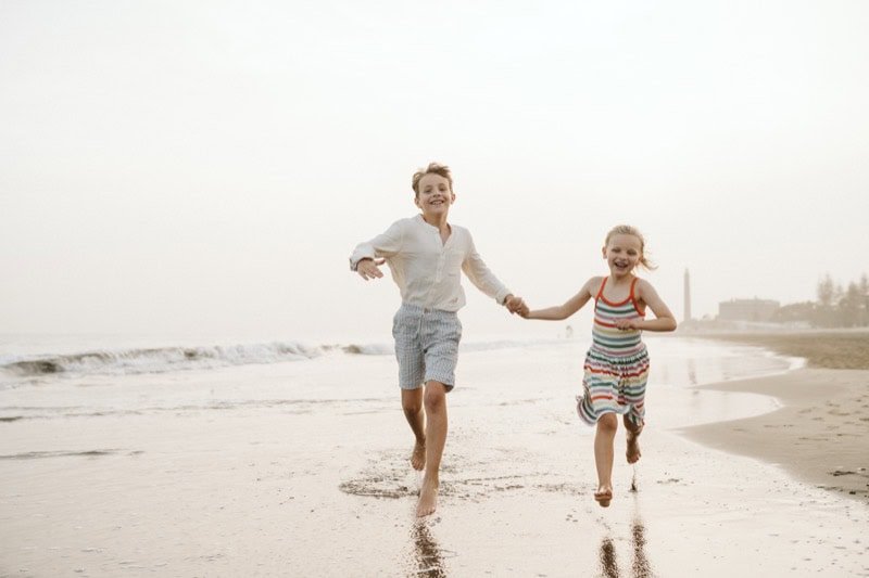 Niños de la mano en la playa